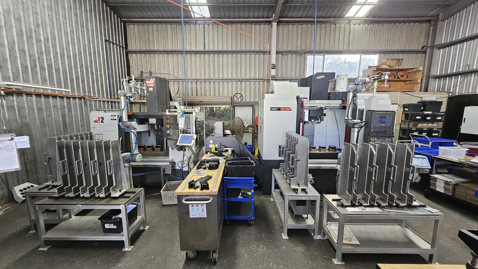 Cobot machine tending cell beside CNC machines